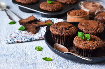 Chocolate muffins with nuts and peanut butter on a concrete background