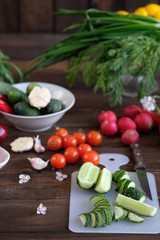 vegetables sliced for a salad on a cutting board, on an old wooden table
