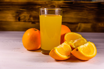 Oranges and glasses with orange juice on a wooden table