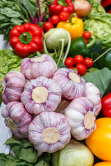 Fresh vegetables - garlic, cauliflower, greenery, onion on a picnic table on a summer day.