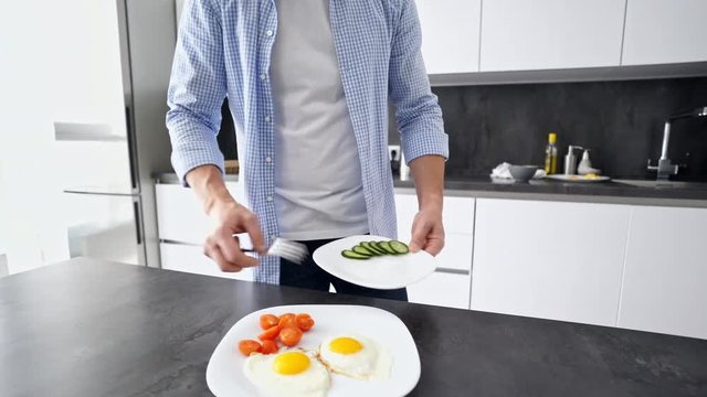 Cropped view of mature man preparing to eat of his breakfast while standing at the kitchen at home