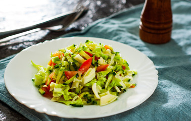 fresh vegetables salad with cabbage, tomato and cucumber in plate on table
