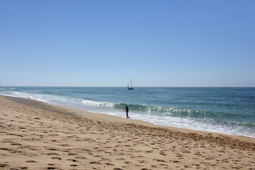 Girl walking alone in the beautiful beach of Green Coast (Costa Verde) and the surroundings