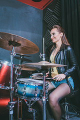 Fototapeta na wymiar Woman playing the drums in music school rehearsal room