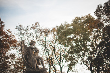 Cemetery on sunny autumn aftetnoon. Golden yellow twilight. Abandoned old statue of an angel...