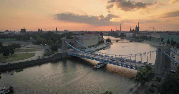 Widok z lotu ptaka na mosty, statek na rzece oraz zachodzące słońce - Wrocław, Polska