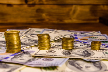 Stack of the coins on the one hundred dollar bills
