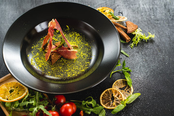 Tasty cream soup with bacon on black background