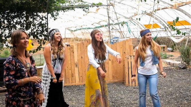 nice group of alternative freedom modern ladies caucasian female with hippies clothes having fun together celebrating with joy and happiness. dance with music to enjoy the life. outdoor joyful concept
