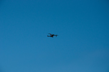 Black quadrupter with propellers flies in the sky and photographs landscapes