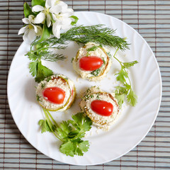 Appetizer with zucchini and tomatoes on a white plate