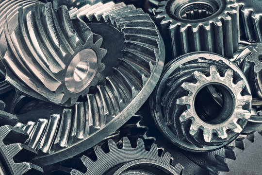 Close-up of various steel gear wheels. Cogged parts in duplex toning. Abstract technical background from the pile of metallic cogwheels. Idea of quality, engineering industry and technology.