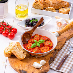 Baked mini meatballs in tomato sauce with basil