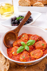 Baked mini meatballs in tomato sauce with basil