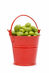 Full bucket of green peas on a white background