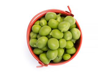 Full bucket of green peas on a white background, top view