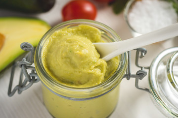 Homemade Green Avocado Spread in Jar. Vegan Raw and Healthy Fresh Food Concept.