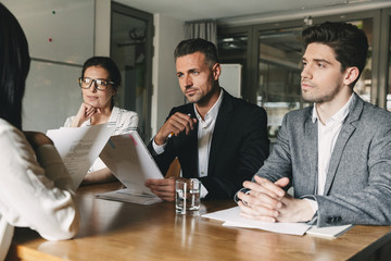 Business, career and placement concept - committee of business people sitting at table in office,...