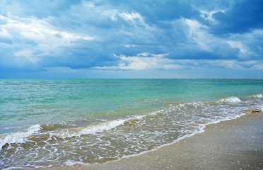 Dark Rain Clouds over turquoise Sea and sand Beach