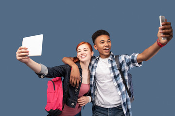 Obraz premium Our selfie. Happy nice man hugging his girlfriend while taking a selfie with her