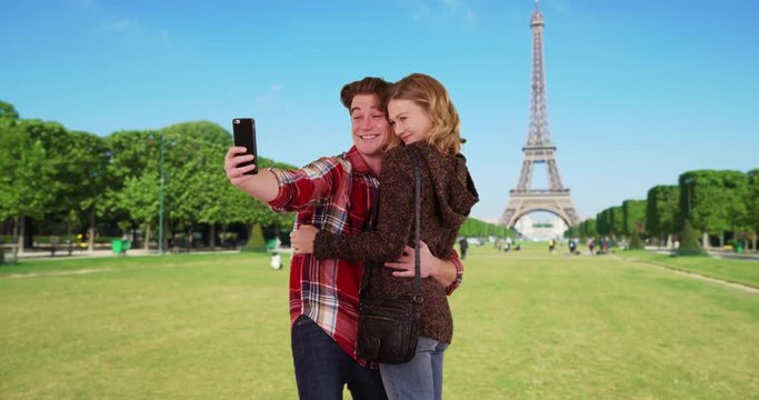 Cheerful millennial couple taking a selfie in Paris, Attractive male and female take pictures to share with friends on social media, 4k