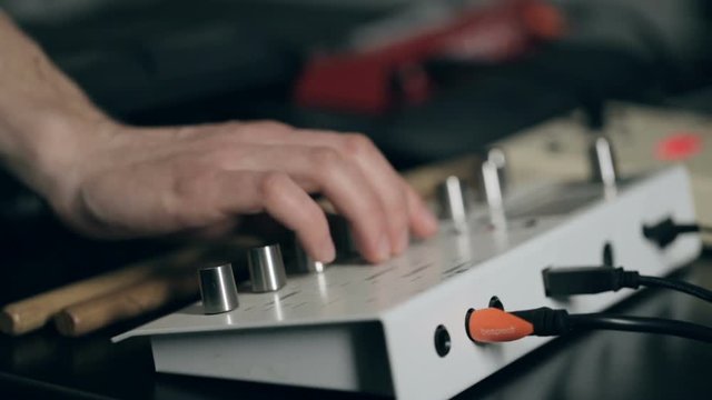 Extremely close up shot of musician's hand tune synthesizer