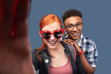 Happy couple. Pleasant nice woman taking a selfie while standing together with her boyfriend