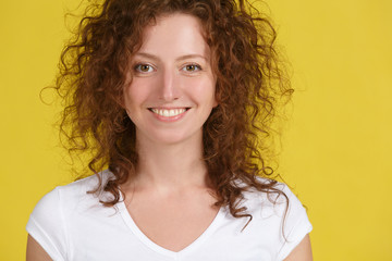 Closeup portrait of cheerful shaggy hairstyle young woman wearing her ginger hair, smiling happily. Pretty girl dressed in white t-shirt looking at camera with excited joyful smile. Youth, lifestyle