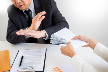Businessman refusing or rejecting money in the envelope - anti bribery and corruption concepts.