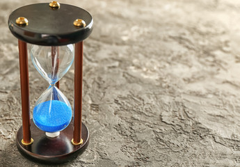 Hourglass on grey textured background. Time management concept