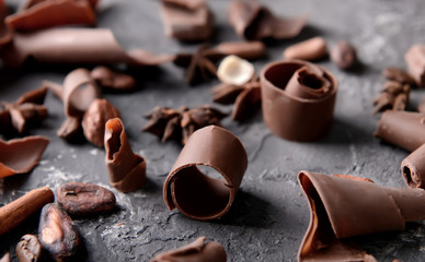 Chocolate curls with beans on textured background