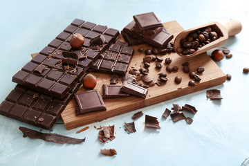 Tasty chocolate with coffee beans on wooden board