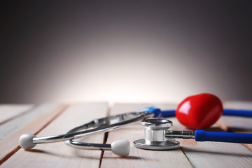 Medical stethoscope with heart on wooden table. Health care concept