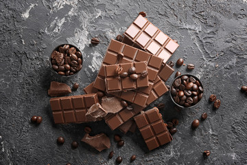 Chocolate pieces with coffee beans on grey textured background