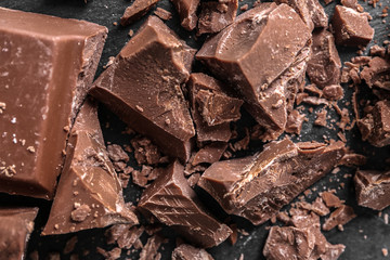 Pieces of chocolate on dark background, closeup