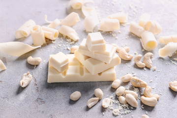 White chocolate pieces with nuts on grey background
