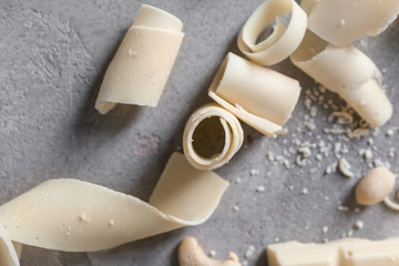 White chocolate curls on grey background, closeup