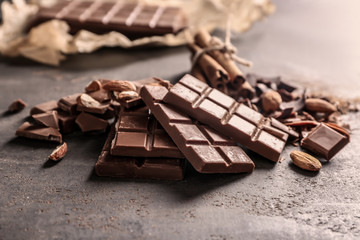 Milk chocolate pieces with almonds on grey background