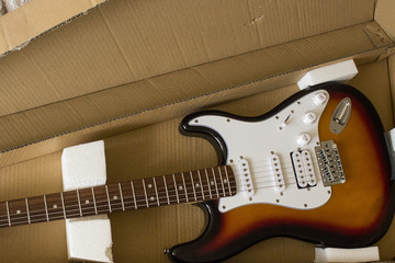 electric guitar is in a cardboard box