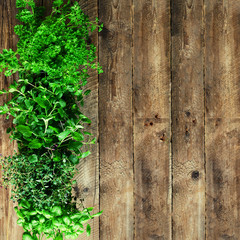 Abstract spring or summer concept. Organic herbs (melissa, mint, thyme, basil, parsley) on wooden...