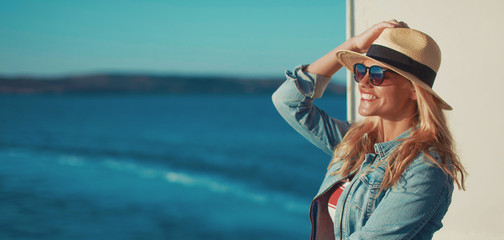 Young blonde woman traveler posing on cruise ship deck banner