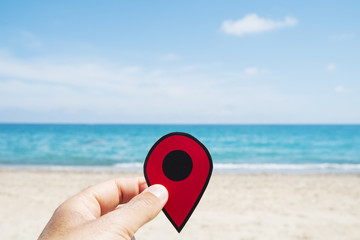 man with a red marker in his hand on the beach