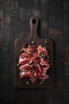 Traditional Spanish Jamon Serrano ham, Prosciutto Crudo, Parma ham, Italian antipasto, served with capers.