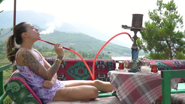 On vacation in Alanya, a girl smokes a hookah