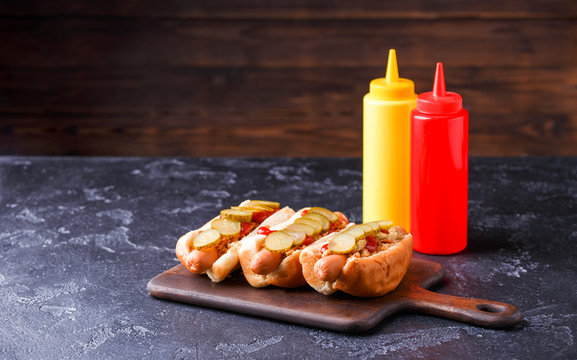Image of hotdogs on cutting board at table