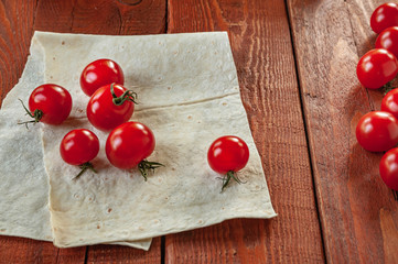Naklejka na ściany i meble cherry tomatoes and bread on wooden background