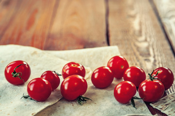 cherry tomatoes and bread on wooden background, soft focus.