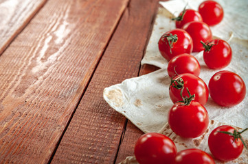 cherry tomatoes and bread on wooden background