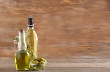 Bottles with olive oil on wooden background