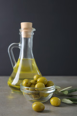 Jug with olive oil on table